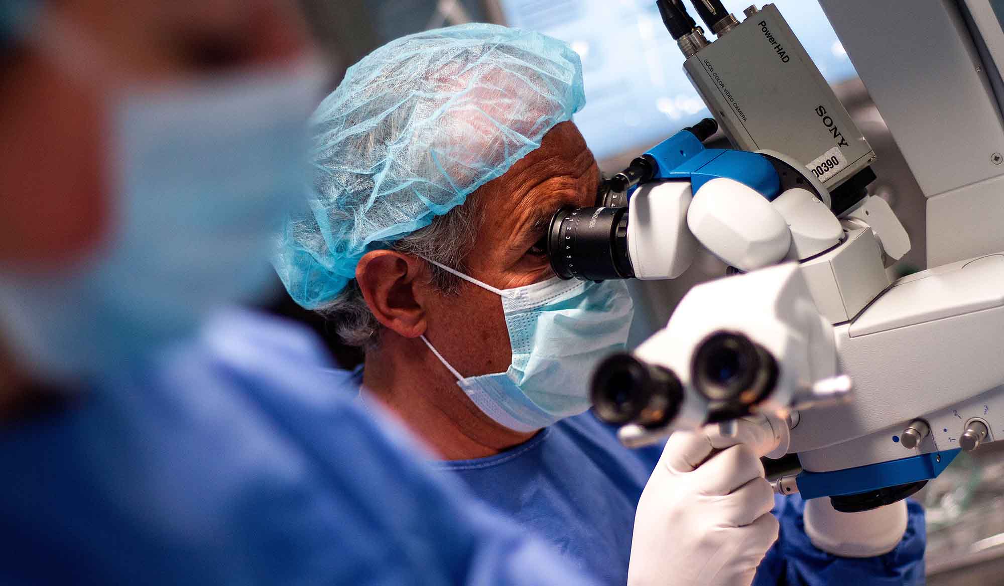 Profesional de Área Oftalmológica Avanzada trabajando con un microscopio quirúrgico